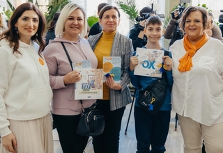 Ukrainian women and youth refugees standing with the coordinator at UNFPA Safe Space
