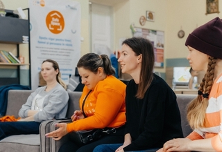 Four women sitting on a couch and engaged in a discussion at UNFPA Safe Space