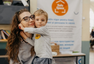Anastasia is posing with her son at the UNFPA Safe Space