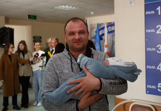Tatăl ține în brațe copilul nou-născut 