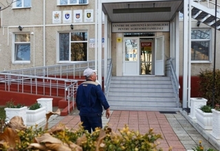 A man standing in front of the Aggressors' Centre in Drochia