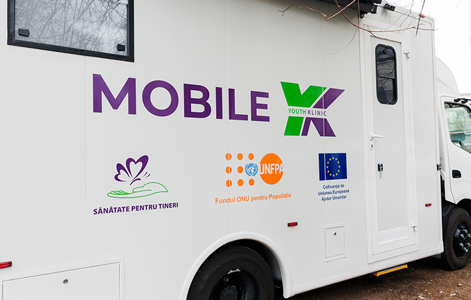 The view of the mobile youth health clinic from the side with the branding "Mobile YK" and partner logos