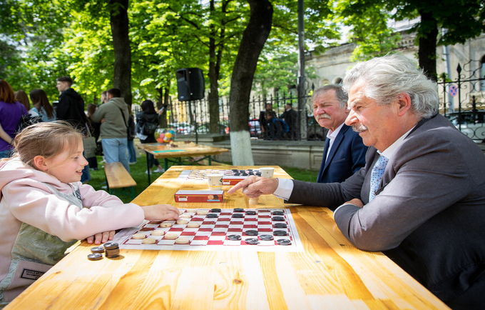 A grandfather and his niece playing checkers on Family Day