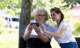  Voluntara Cătălina Neghina îi arată fostei sale profesoare Elena Gobjilă cum să navigheze pe internet, folosind telefonul mobil