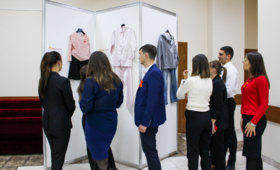 5 femei și 2 bărbați analizează hainele expuse în cadrul expoziției