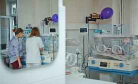 The view of the mother and doctor looking inside the incubator from afar