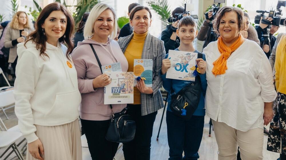 Ukrainian women and youth refugees standing with the coordinator at UNFPA Safe Space