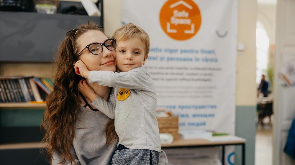 Anastasia is posing with her son at the UNFPA Safe Space