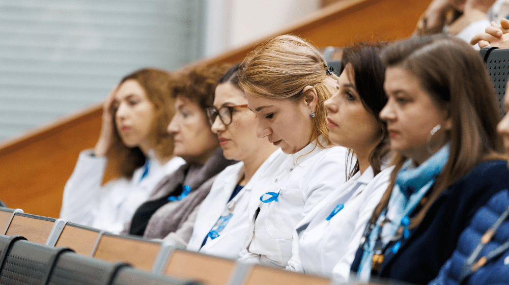 Six women listening to speeches at the event