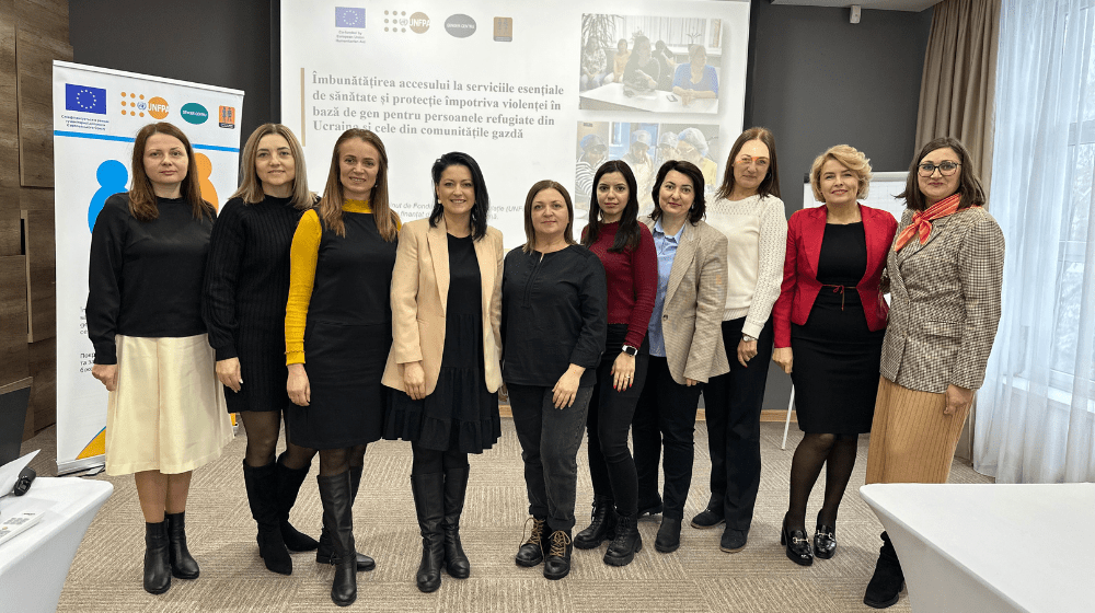 Ten women looking at the camera, smiling with a banner in the background