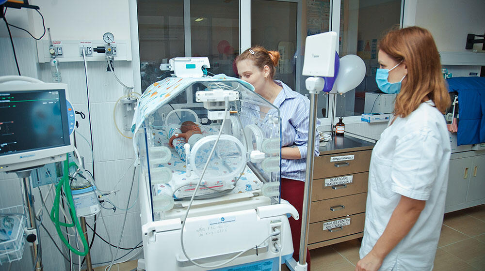 Alina looking at her baby in the incubator