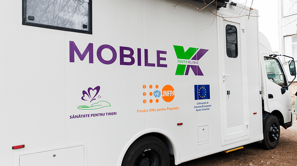 The view of the mobile youth health clinic from the side with the branding "Mobile YK" and partner logos