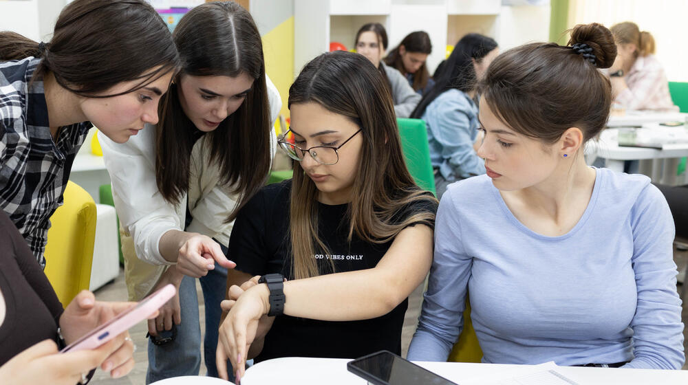 Four girls analyzing how the watch works