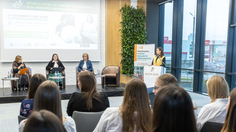 3 speakers on a stage, at the public debate event „Infertilitatea în context demografic și al sănătății reproductive”