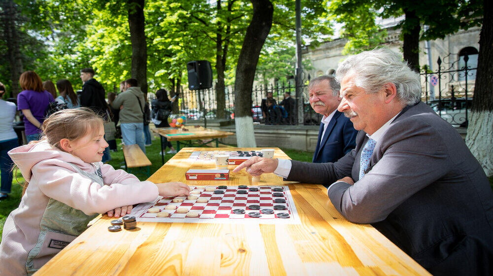 A grandfather and his niece playing checkers on Family Day