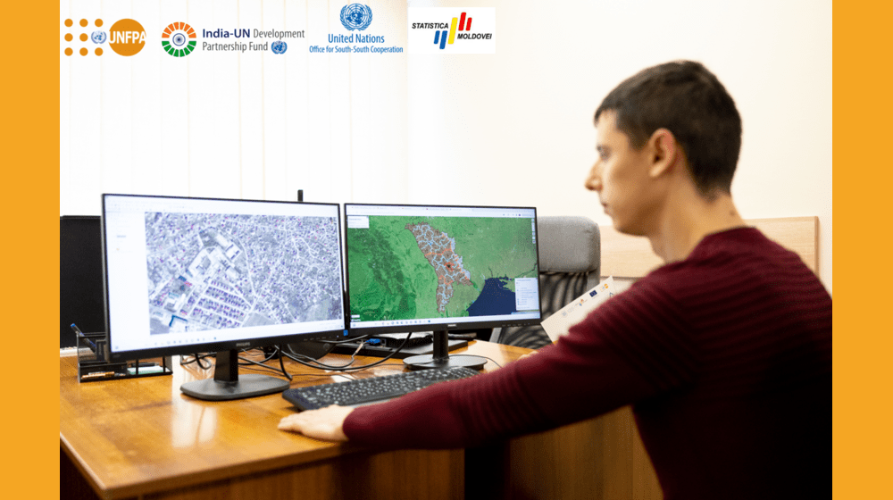 A man is looking into the computer, he sits in front of 2 screens, which show data