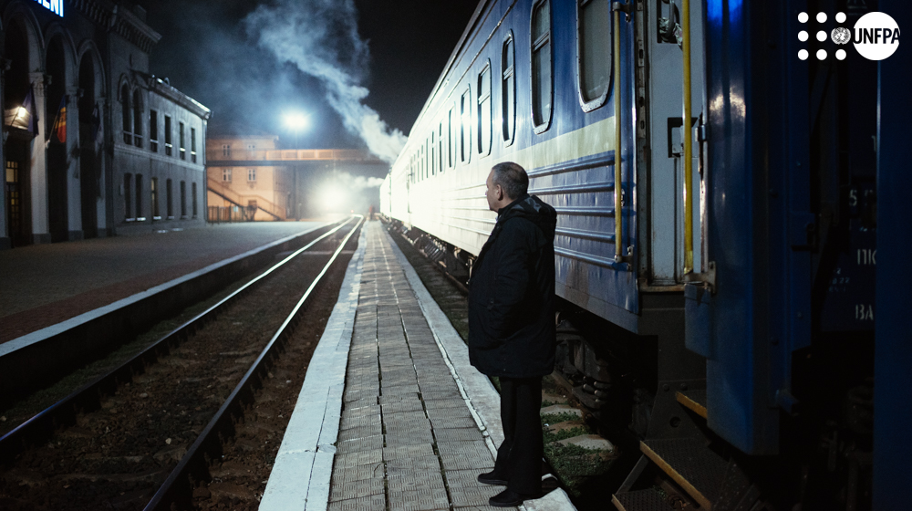 a person standing on a platform next to a train